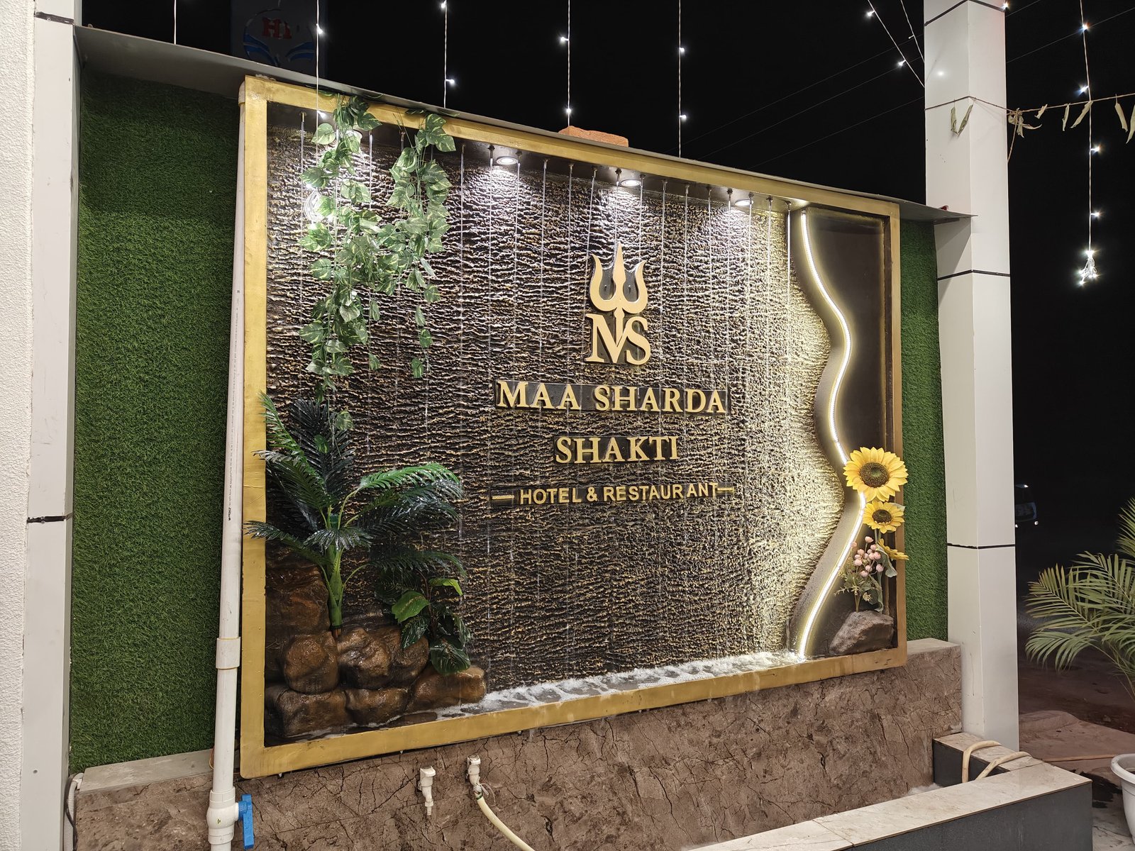 Maa Sharda Shakti Hotel entrance with decorative waterfall sign